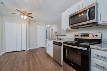 A kitchen with a stove, oven, and microwave.